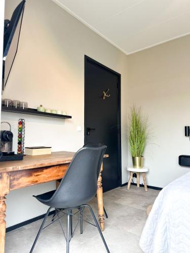 a bedroom with a desk and a chair in front of a door at Bed & Breakfast Waterpoort - incl licht ontbijt, airco en parking in Sneek