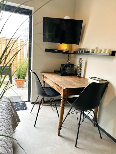 a desk with two chairs and a television on a wall at Bed & Breakfast Waterpoort - incl licht ontbijt, airco en parking in Sneek