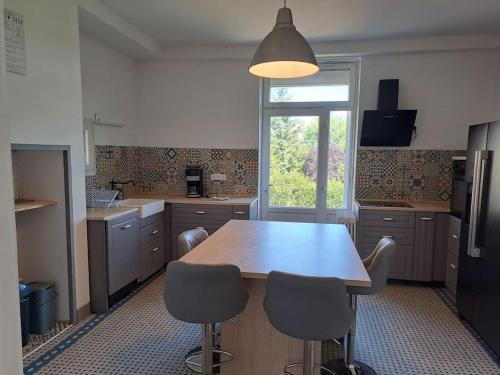 une cuisine avec une grande table et des chaises en bois dans l'établissement Maison du Maître Tanneur, à Château-Renault