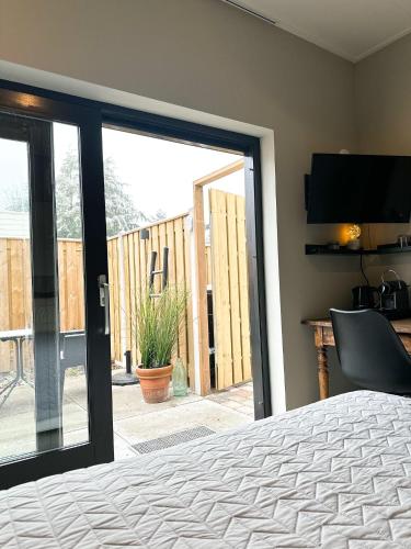 a bedroom with a sliding glass door to a patio at Bed & Breakfast Waterpoort - incl licht ontbijt, airco en parking in Sneek