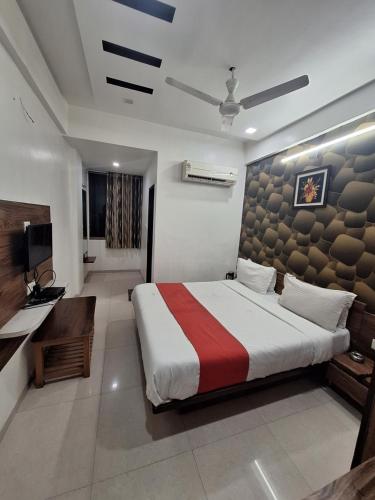 um quarto com uma cama grande e uma televisão em Hotel Nayan palace em Kalol