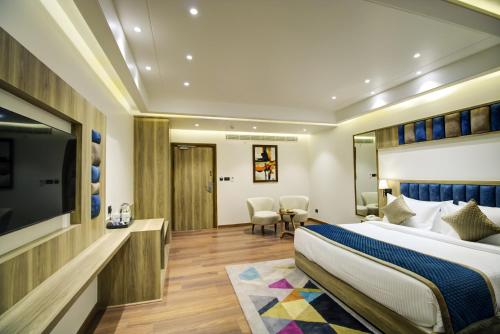 a hotel room with a bed and a flat screen tv at Cygnett Style Ganga in Jaipur