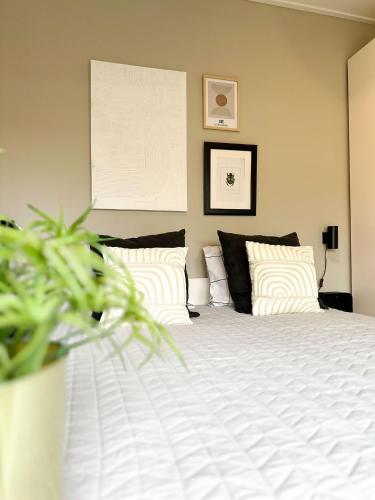 a bedroom with a bed with white sheets and pillows at Bed & Breakfast Waterpoort - incl licht ontbijt, airco en parking in Sneek