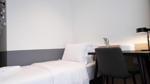 a bedroom with a bed and a desk with a chair at VicHaus Serviced Apartment in Singapore