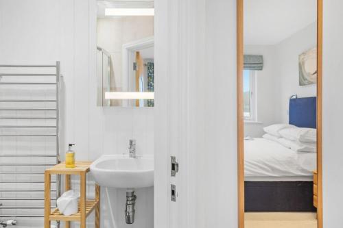 a bathroom with a sink and a bed at 4 Out Of The Blue, Croyde in Croyde