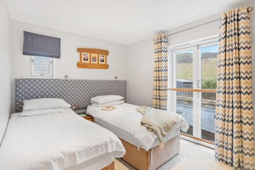 two beds in a room with a window at 4 Out Of The Blue, Croyde in Croyde