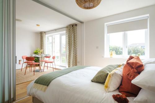 Hauzify I Cavendish flats في West Drayton: غرفة نوم بسرير وطاولة مع كراسي
