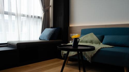 a living room with a blue couch and a table at VicHaus Serviced Apartment in Singapore