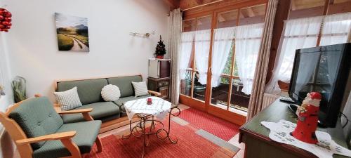 a living room with a couch and a tv at Hotel - Pension - Heidelberg inkl. Chiemgaukarte in Ruhpolding