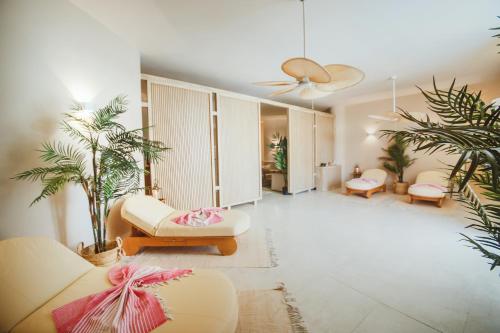 a living room with two couches and palm trees at Spacious studio in Perivolia tou Trikomou