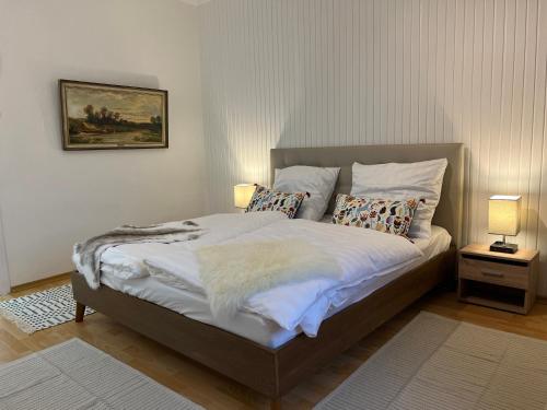 ein Schlafzimmer mit einem Bett mit zwei Lampen und einem Gemälde in der Unterkunft Casa Estrella in Duisburg