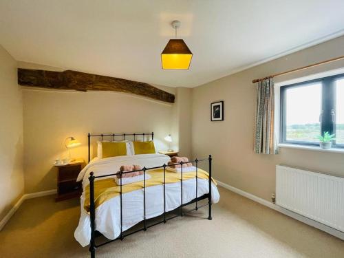 1 dormitorio con cama y ventana grande en North Mere Rural Cottages en Kenilworth