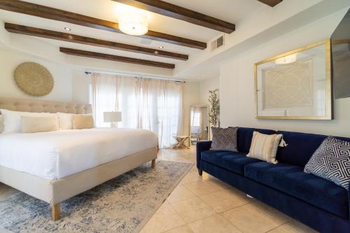 a bedroom with a bed and a blue couch at Opal by AvantStay Central Scottsdale Luxe Home in Scottsdale