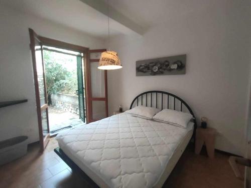 sypialnia z dużym białym łóżkiem i oknem w obiekcie Casa Ulivo con Piscina w mieście Diano Castello