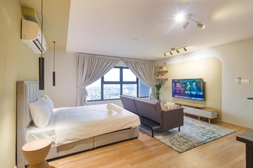 een slaapkamer met een bed, een bank en een televisie bij Arte Cheras in Kuala Lumpur