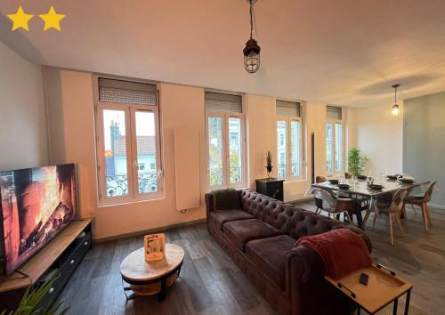 un salon avec un canapé, une télévision et une table dans l'établissement Le Roof Top Jacquard, à Calais