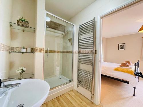 a bathroom with a tub and a sink and a shower at North Mere Rural Cottages in Kenilworth