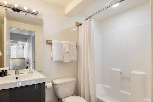 La salle de bains blanche est pourvue d'un lavabo et de toilettes. dans l'établissement Chickaree by AvantStay A-Frame w Mountain Views, à Tahoe City