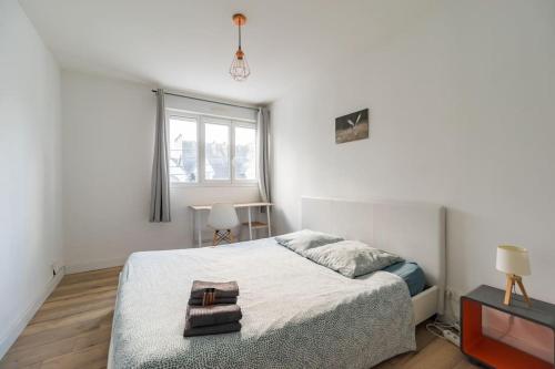 a white bedroom with a bed and a window at 3 bedroom apartment with terrace - Saint-Brieuc in Saint-Brieuc