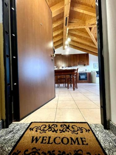 a door leading into a kitchen with a welcome mat at Mansarda antica Milano in San Giuliano Milanese