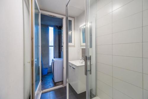 a white bathroom with a shower and a sink at 3 bedroom apartment with terrace - Saint-Brieuc in Saint-Brieuc