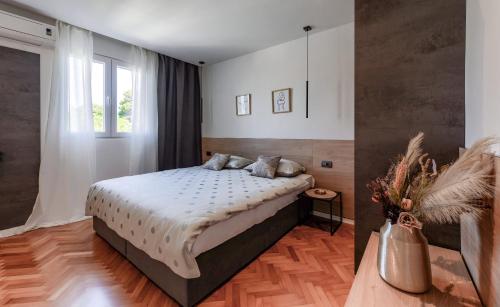 a bedroom with a bed and a window at Apartments Čolak in Zadar