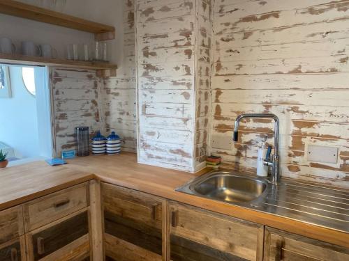 a kitchen with a sink and a wooden wall at Central Sea View maisonette in Hastings