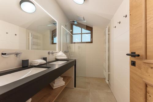 La salle de bains est pourvue de 2 lavabos et d'un miroir. dans l'établissement Haus Ennsegg by Schladming-Appartements, à Haus im Ennstal