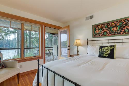 a bedroom with a large bed and a balcony at Goss Lake Chalet by AvantStay Lakefront w Dock in Langley
