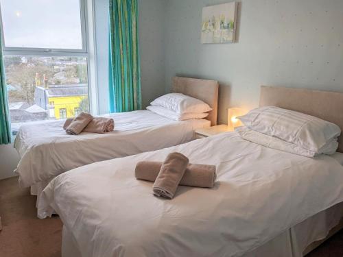Duas camas com toalhas num quarto em 2 Bed in Tenby FB164 em Tenby