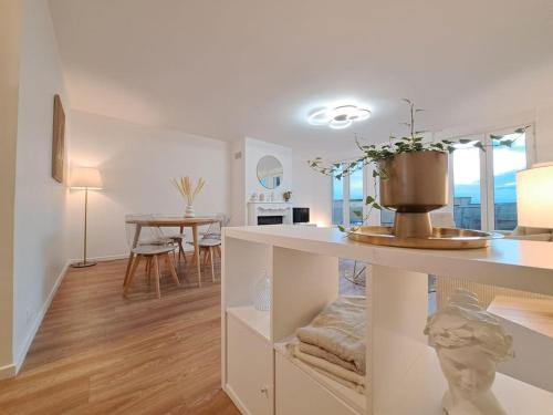 une cuisine blanche avec une table et une salle à manger dans l'établissement Appartement 