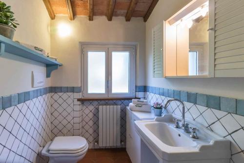 een badkamer met een wastafel, een toilet en een spiegel bij Casa Amedeo in Lucca