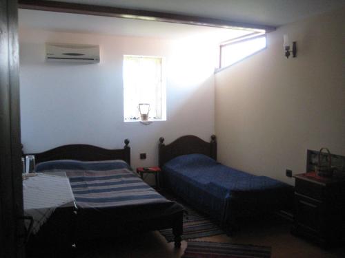 Beeva House في Merdanya: غرفة صغيرة بسريرين ونافذة