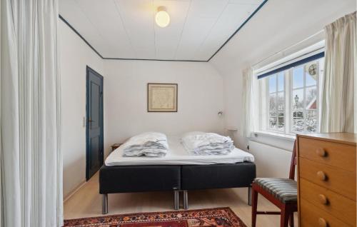 a small bedroom with a bed and a window at Cozy Home In Fan With Kitchen in Fanø