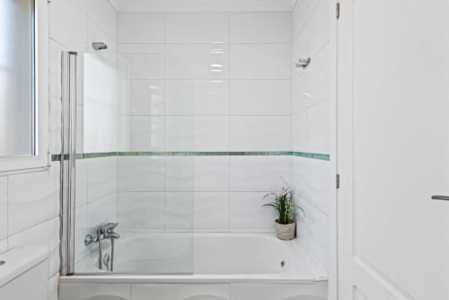 a white bathroom with a tub and a shower at Apartamento Casita Blanca - PlusHolidays in Calpe