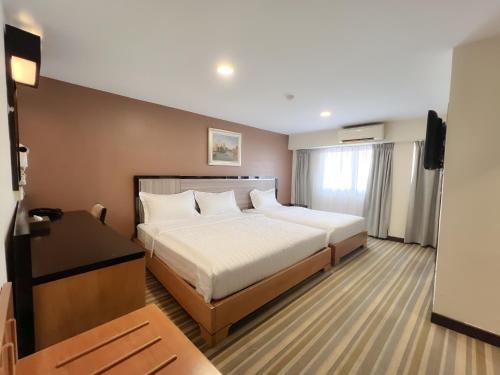 una camera d'albergo con letto e TV di Hallmark Express Hotel a Malacca