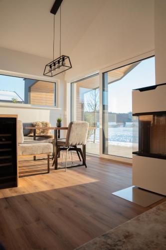 a living room with a fireplace and a table with a chair at Traumzeit Lodge 57 in Loipersdorf bei Fürstenfeld