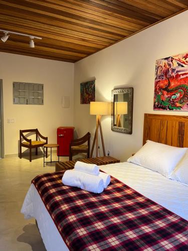 a bedroom with a bed with two towels on it at Casa Arte Cabore in Paraty