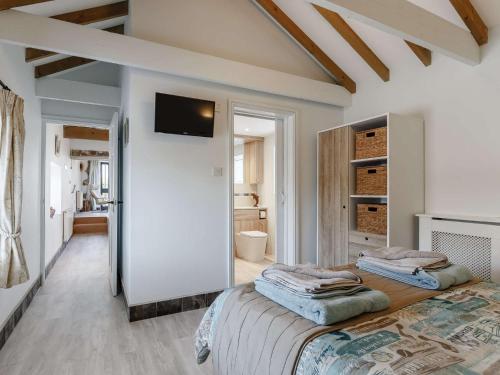 1 dormitorio con 1 cama grande y TV en la pared en 1 Bed in Widemouth Bay 81124, en Poundstock