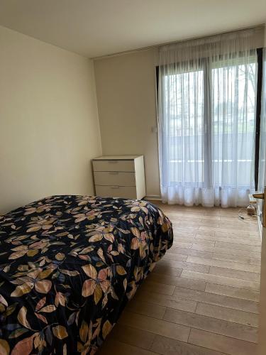 une chambre avec un lit, une commode et une fenêtre dans l'établissement Appartement charmant à Issy-les-Moulineaux 49 m² avec terrasse, à Issy-les-Moulineaux