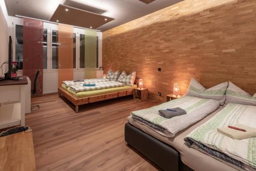 1 dormitorio con 2 camas y pared de ladrillo en Andi's BnB en Zug