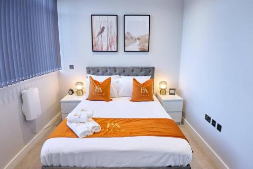 a bedroom with a large bed with orange pillows at Pluxa Tangerine - Pluxa Gem Corporate Access, Workspace in Harrow