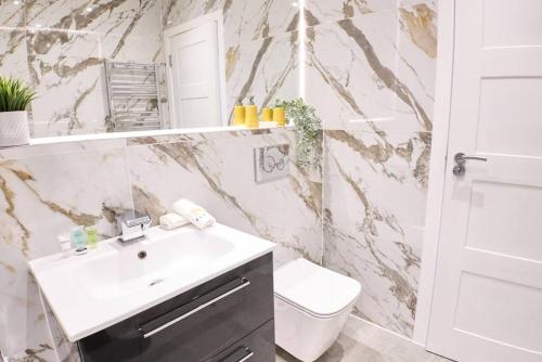 a bathroom with a sink and a toilet at Pluxa Tangerine - Pluxa Gem Corporate Access, Workspace in Harrow