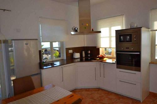a kitchen with white cabinets and a stove top oven at Appartement Caldera in Los Llanos de Aridane