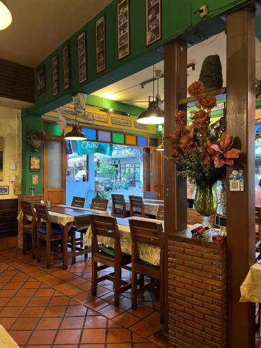 a dining room with a table and chairs in a restaurant at Baan Glang Soi Restaurant & Guesthouse in Bangkok