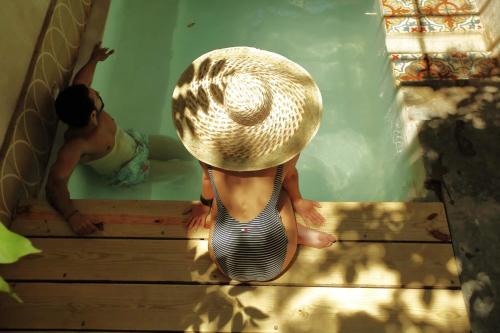 two children are sitting on the stairs in a swimming pool at FIXIE LOFTS Slow Life Villa in Santo Domingo