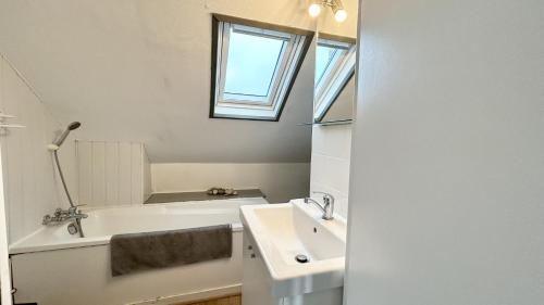 une salle de bain avec un lavabo et une baignoire dans l'établissement Les Tilleuls, au Crotoy