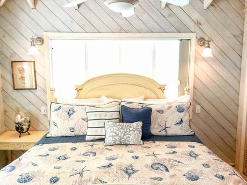 a bedroom with a large bed with blue and white pillows at Sea Smile in Staniel Cay