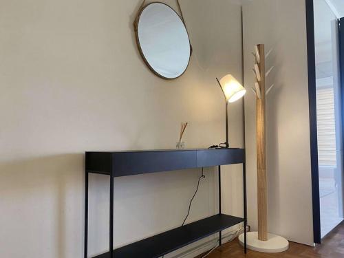 une pièce avec une table avec un miroir et une lampe dans l'établissement Le MONDAIN - Studio Palais des festivals-Front Mer, à Cannes