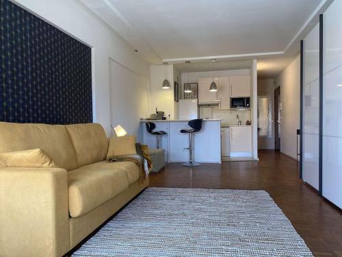un salon avec un canapé et une cuisine dans l'établissement Le MONDAIN - Studio Palais des festivals-Front Mer, à Cannes